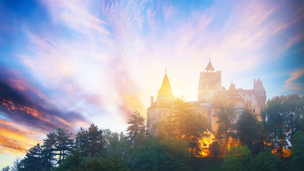 Landscape with medieval Bran castle known for the myth of Dracula at sunset, Brasov landmark, Transylvania, Romania, Europe