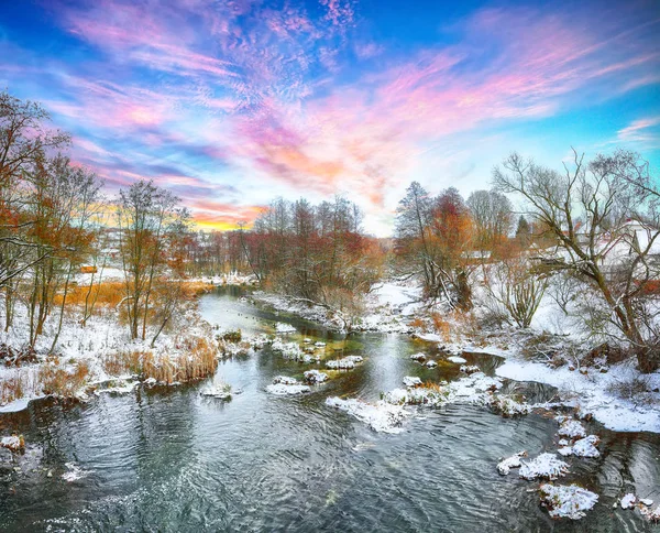 Paisagem de inverno por um rio ao pôr do sol — Fotografia de Stock