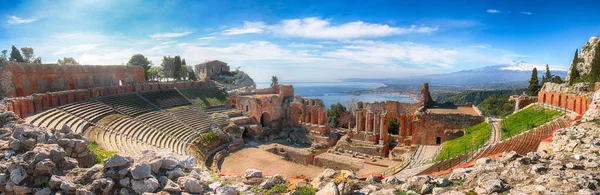 Ruinas del antiguo teatro griego en Taormina y el volcán Etna en t —  Fotos de Stock