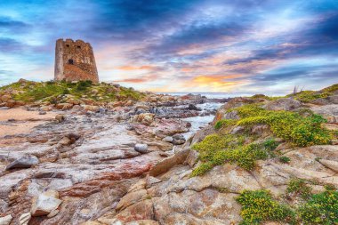 Orosei Körfezi'ndeki Bari Sardo kulesinin muhteşem gün batımı manzarası.