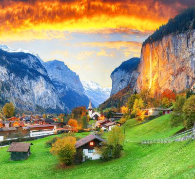 Gün batımında muhteşem Staubbach şelalesi ve İsviçre Alpleri ile Lauterbrunnen Vadisi 'nin büyüleyici sonbahar manzarası. Konum: Lauterbrunnen Köyü, Berner Oberland, İsviçre, Avrupa.