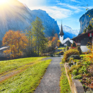 Ünlü kilisesi ve Staubbach şelalesiyle turistik alp köyü Lauterbrunnen 'in muhteşem sonbahar manzarası. Konum: Lauterbrunnen Köyü, Berner Oberland, İsviçre, Avrupa.
