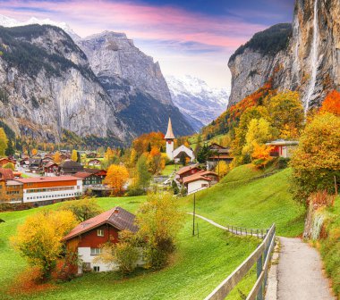 Ünlü kilisesi ve Staubbach şelalesiyle turistik alp köyü Lauterbrunnen 'in muhteşem sonbahar manzarası. Konum: Lauterbrunnen Köyü, Berner Oberland, İsviçre, Avrupa.
