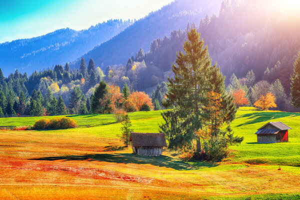 Splendid view of alpine meadow near Wagenbruchsee (Geroldsee) lake with wooden huts and Zugspitze mountain range on background.. Location: Geroldsee, Krun, Bavarian Alps, Germany, Europe