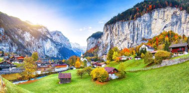Lauterbrunnen Vadisi 'nin büyüleyici sonbahar manzarası muhteşem Staubbach şelalesi ve arka planda İsviçre Alpleri. Konum: Lauterbrunnen Köyü, Berner Oberland, İsviçre, Avrupa.