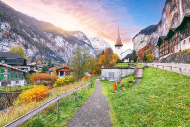 Lauterbrunnen köyünün fonda Staubbach şelalesi ve İsviçre Alpleri ile muhteşem sonbahar manzarası. Konum: Lauterbrunnen Köyü, Berner Oberland, İsviçre, Avrupa.