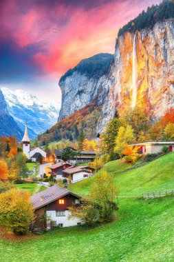 Gün batımında muhteşem Staubbach şelalesi ve İsviçre Alpleri ile Lauterbrunnen Vadisi 'nin büyüleyici sonbahar manzarası. Konum: Lauterbrunnen Köyü, Berner Oberland, İsviçre, Avrupa.
