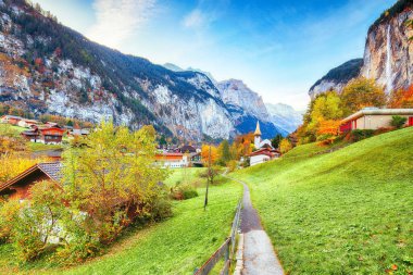 Lauterbrunnen Vadisi 'nin büyüleyici sonbahar manzarası muhteşem Staubbach şelalesi ve arka planda İsviçre Alpleri. Konum: Lauterbrunnen Köyü, Berner Oberland, İsviçre, Avrupa.