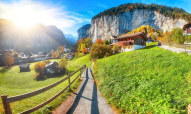 Arka planda muhteşem Staubbach şelalesi ve İsviçre Alpleri olan Lauterbrunnen Vadisi 'nin şaşırtıcı sonbahar manzarası. Konum: Lauterbrunnen Köyü, Berner Oberland, İsviçre, Avrupa.