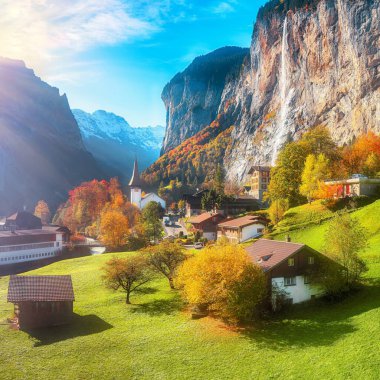 Arka planda muhteşem şelale Staubbach ve İsviçre Alpleri olan Lauterbrunnen köyünün fantastik sonbahar manzarası. Konum: Lauterbrunnen Köyü, Berner Oberland, İsviçre, Avrupa.