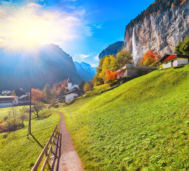 Arka planda muhteşem şelale Staubbach ve İsviçre Alpleri olan Lauterbrunnen köyünün fantastik sonbahar manzarası. Konum: Lauterbrunnen Köyü, Berner Oberland, İsviçre, Avrupa.