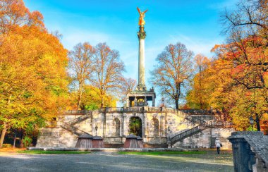 Barış Meleği (Friedensengel) anıtının büyüleyici sonbahar manzarası. Şehir parkındaki bir sütundaki altın melek heykeli. Konum: Münih, Bavyera, Almanya, Avrupa.