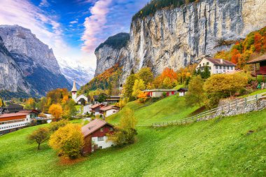 Arka planda muhteşem Staubbach şelalesi ve İsviçre Alpleri olan Lauterbrunnen Vadisi 'nin şaşırtıcı sonbahar manzarası. Konum: Lauterbrunnen Köyü, Berner Oberland, İsviçre, Avrupa
