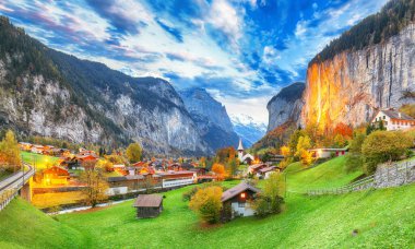 Gün batımında muhteşem Staubbach şelalesi ve İsviçre Alpleri ile Lauterbrunnen Vadisi 'nin dramatik sonbahar manzarası. Konum: Lauterbrunnen Köyü, Berner Oberland, İsviçre, Avrupa.