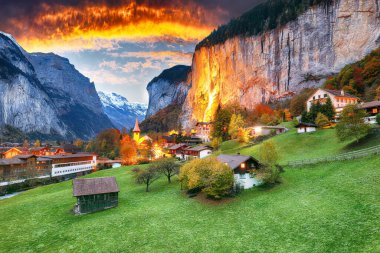 Gün batımında muhteşem Staubbach şelalesi ve İsviçre Alpleri ile Lauterbrunnen Vadisi 'nin dramatik sonbahar manzarası. Konum: Lauterbrunnen Köyü, Berner Oberland, İsviçre, Avrupa.
