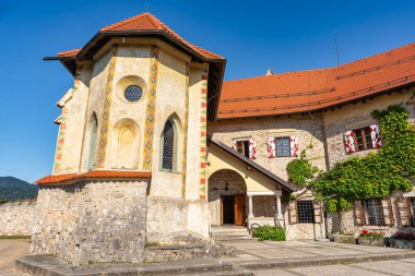 Slovenya 'daki göl kenarındaki uçurumun kenarındaki Bled Gölü şatosu binaları