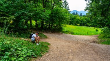 Turist, Slovenya 'daki Vintgar Doğa Parkı' nda dinlenmek için mola veriyor.