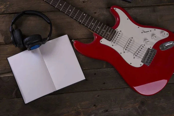 Guitar wallpaper with microphone, headset, cables and wooden background, with writing pad