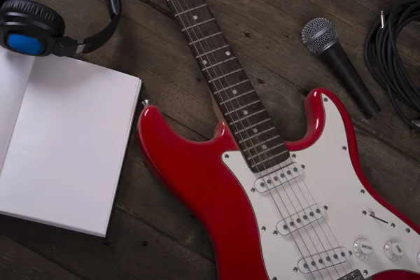 Guitar wallpaper with microphone, headset, cables and wooden background, with writing pad