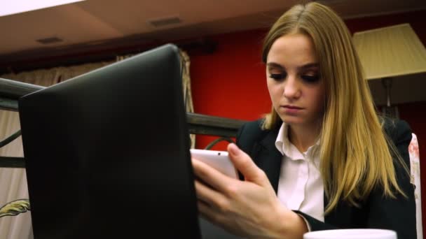 年轻女孩与智能手机和笔记本电脑在餐厅 — 图库视频影像