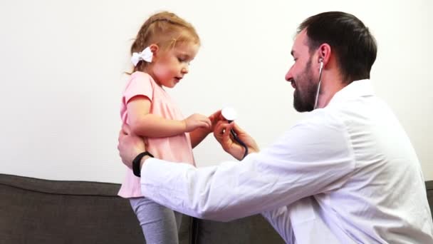 Ein Vater und seine süße Tochter spielen in Arzt. — Stockvideo