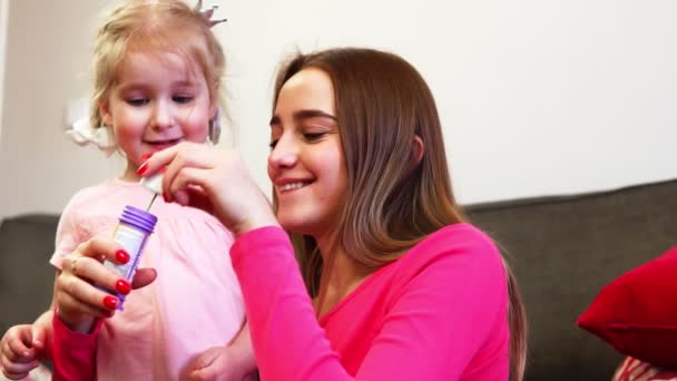 Familia feliz. Madre o hermana le enseña al bebé a soplar burbujas en cámara lenta . — Vídeos de Stock