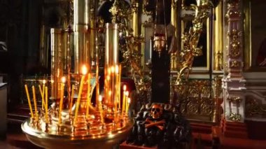 Yanan mumlar altın kilise avize hazır. Orada bir arka plan üzerinde birçok kutsal simgeleri.