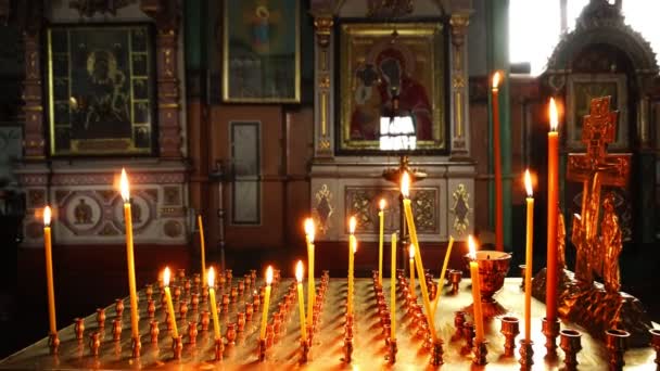 Video schieten in de Christian Church. Aangestoken kaarsen op de achtergrond van het pictogram van de moeder Gods. — Stockvideo