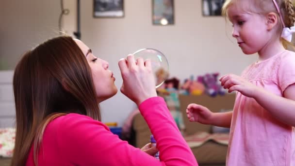 Anne ile kızı oynuyor. Onlar darbe bubbles birlikte. — Stok video
