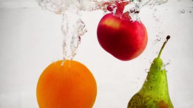 Ağır çekim video armut, elma ve portakal su kabarcıkları ile içine düşme. Meyve izole beyaz zemin üzerine.