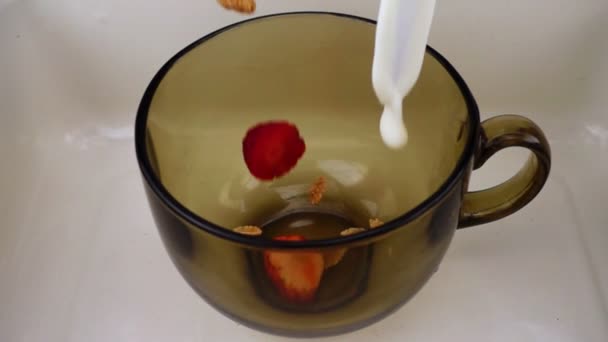 Corn flakes och bär är kastades i en skål och hällde mjölk. Video nyttig frukost i långsam takt. — Stockvideo