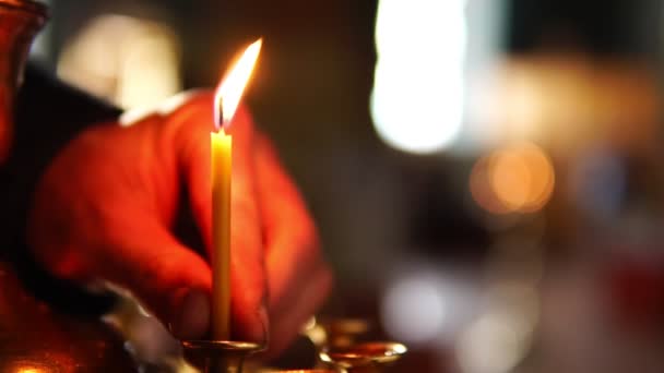 Die Menschliche Hand Großaufnahme Legt Eine Kerze Einen Kerzenständer Der — Stockvideo