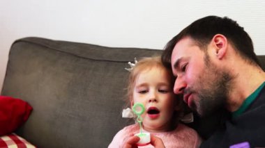 Bir baba çocuğunu darbeler ve birlikte yanardöner bir sabun baloncuklar.