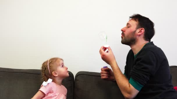 Un padre felice soffia una bolla di sapone e si apre sul naso dei suoi bambini . — Video Stock