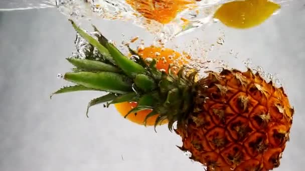 パイナップル オレンジ レモン スローモーションで気泡と水のふれまわり — ストック動画