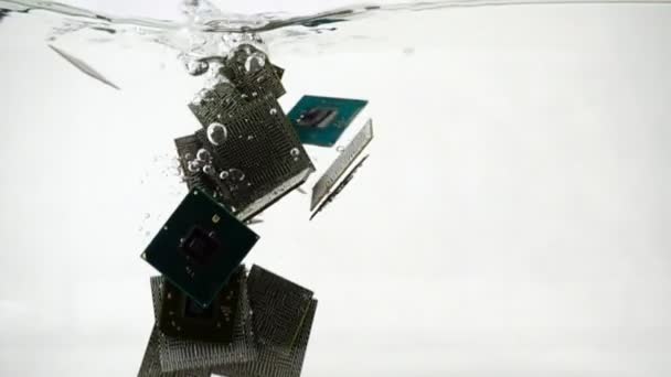 Компьютерные микрочипы падают в воду, замедленное движение — стоковое видео