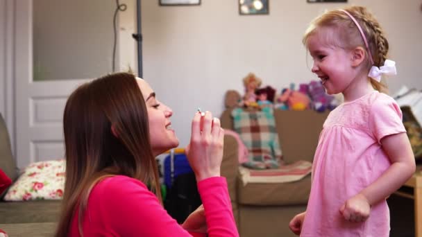 Mutter bläst der Tochter eine Seifenblase ins Gesicht, die in Zeitlupe vor ihrem Gesicht knallt. — Stockvideo