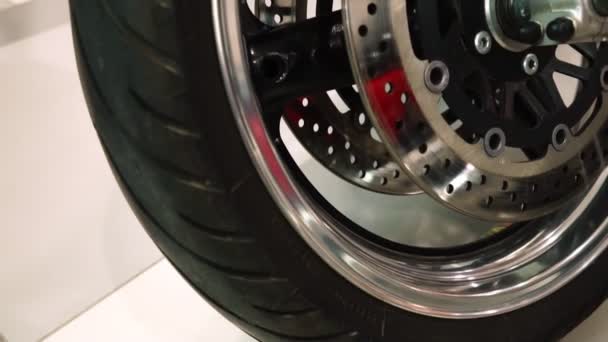 Exposição de motocicletas, Roda dianteira da motocicleta com o disco de freio de perto — Vídeo de Stock