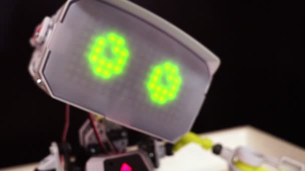 Head of a robot, the robot blinks virtual eyes — Stock Video