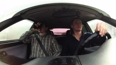 Bir sürücü elinde silah olan bir yolcu taşır. Arabanın içinde videolar.