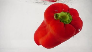 Su sıçramalarına ve kabarcıklar ile taze kırmızı biber düşüyor