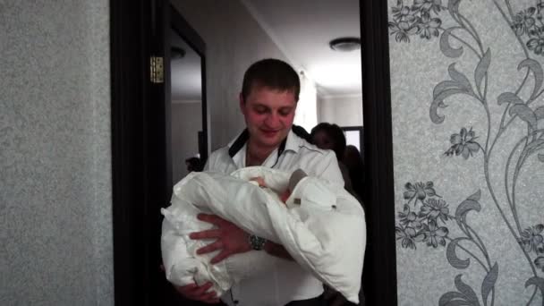 A família retorna da maternidade com um filho recém-nascido nos braços, entra no quarto — Vídeo de Stock