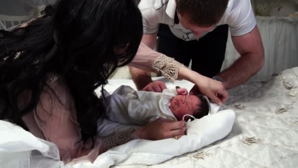 Bebê recém-nascido está dormindo na cama no quarto, os pais cuidam dele — Vídeo de Stock