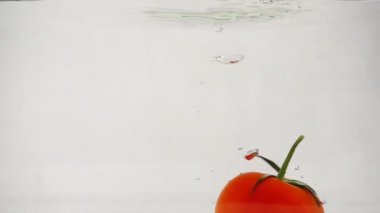 Bir olgun kırmızı domates dönen dalış sualtı merkezi üzerinde beyaz bir arka plan