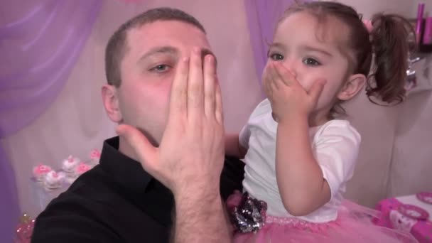 В руках молодого отца маленькая дочь посылает воздушный поцелуй — стоковое видео