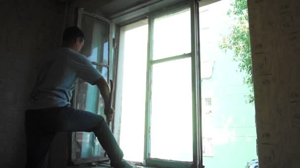 Lipetsk, Russian Federation - August 27, 2018: Man master removes old wooden window from the window frame — Stock Video