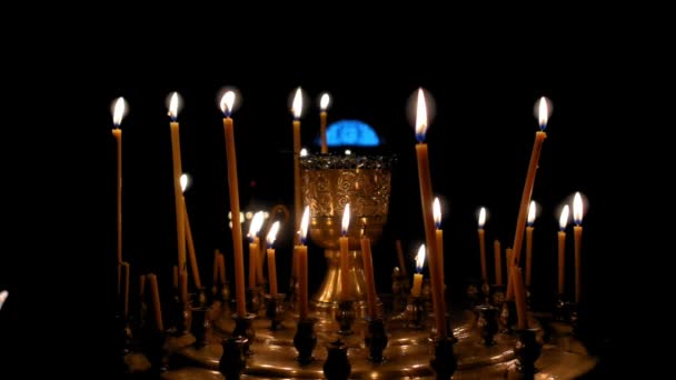 Viele Kerzen brennen auf einem dunklen — Stockvideo