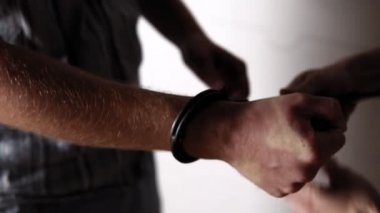 Polis kelepçeleri suçlunun eline takıyor