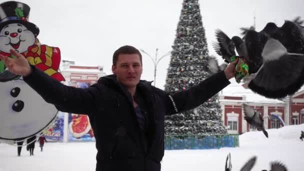 Man feeds pigeons, birds sit on his hands — Stock Video