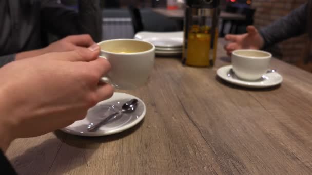 Group of friends people clink and drink tea in the cafe, hands closeup. — Stock Video